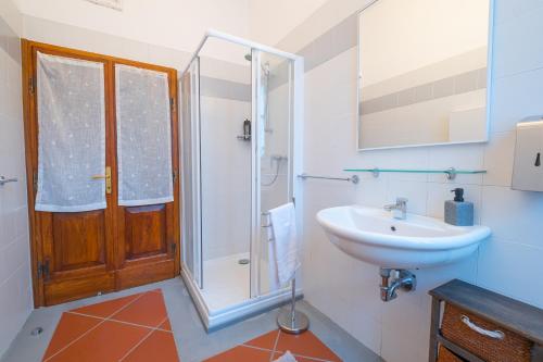 uma casa de banho com um lavatório, um chuveiro e um WC. em Veleia Romana B&B em Rustigazzo