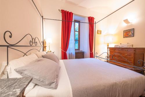 um quarto com uma cama grande e cortinas vermelhas em Veleia Romana B&B em Rustigazzo