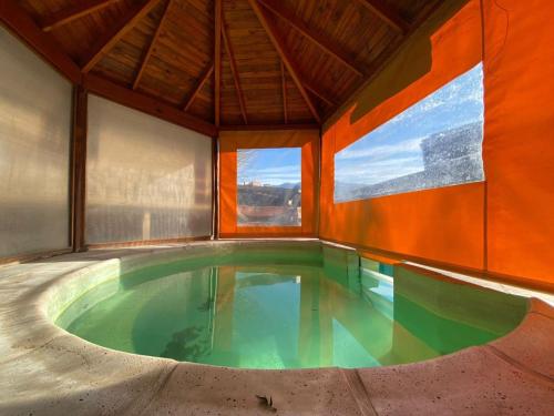 una piscina cubierta en una casa con una gran ventana en Cabañas Luján, en Potrero de los Funes