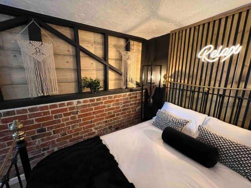 ein Schlafzimmer mit einem Bett mit Ziegelwand in der Unterkunft Hot Tub hideaway! New Forest in Cadnam