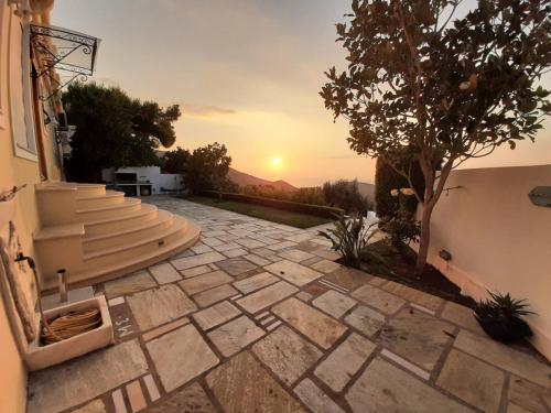 a stone patio with a sunset in the background at Maya's home in Dhaskalión