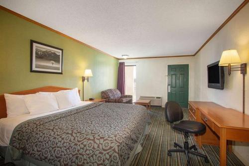 ウィチタにあるEconomy Hotel Wichita 2のベッドとデスクが備わるホテルルームです。