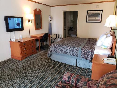 a hotel room with a bed and a flat screen tv at Economy Hotel Wichita- Florence St in Wichita