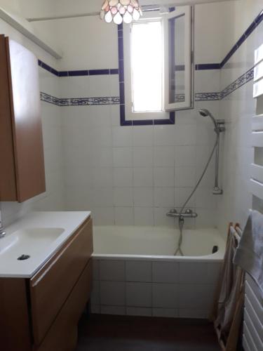 uma casa de banho com uma banheira, um lavatório e uma janela em lumière de provence em Mollégès