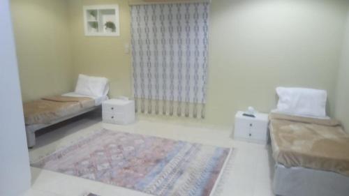 a room with two beds and a couch and a rug at غرف الهدايه 