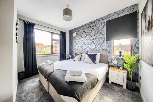 a bedroom with a large bed and a window at LOW RATE - Coventry for 3 BedRoom House with Garden, FREE Netflix and Unlimited Wi-fi - Driveway Parking - AGC in Coventry