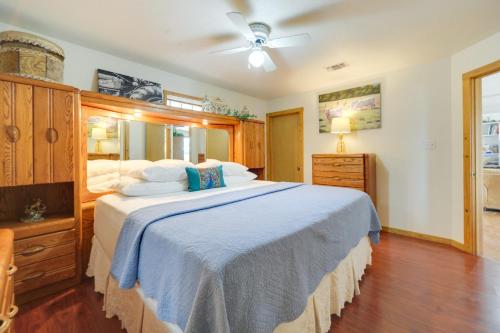 a bedroom with a large bed with a blue blanket at Fredericksburg Retreat with Private Hot Tub and Patio! in Fredericksburg