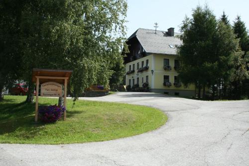 a sign in front of a house with a building at Ferienwohnungen Bachergut in Mariapfarr