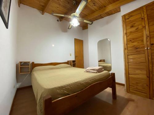 Un dormitorio con una cama y un ventilador de techo. en Cabañas Luján, en Potrero de los Funes