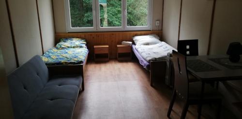 Habitación pequeña con 2 camas y mesa. en Kemp a Loděnice Podolsko - Chatka pro 2 osoby, 