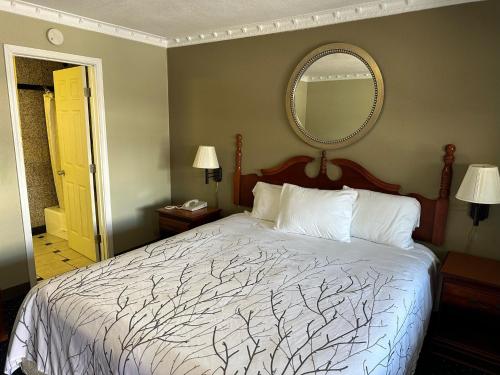 a bedroom with a bed and a mirror on the wall at Western Village Inn in Willits