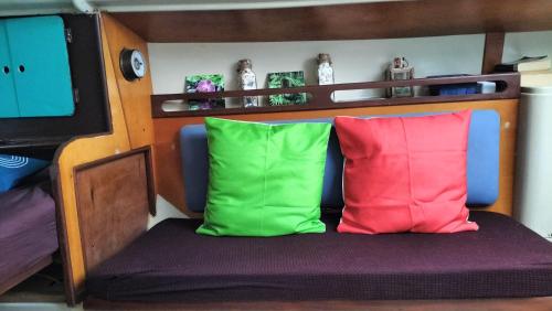 - 2 oreillers colorés installés sur un lit dans la chambre dans l'établissement Bateau Voilier « Brenus lll », à Gruissan