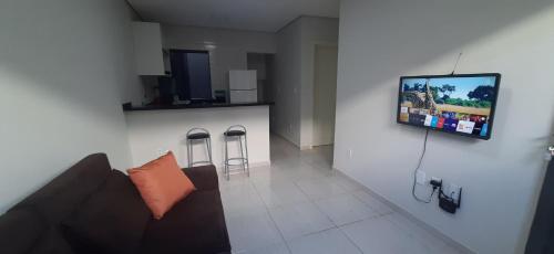 sala de estar con sofá y TV en la pared en Ingá Hospedagem en Porto Velho