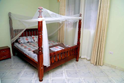 a bed with a canopy in a room at Exciting Lovely 2- bedroom unit in Kampala