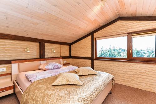 a bedroom with two beds and two windows at Sodyba Gintaras in Priekulė