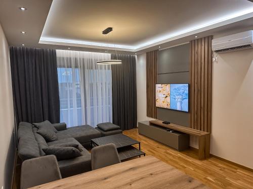 a living room with a couch and a flat screen tv at Enigma Apartment in Ulcinj