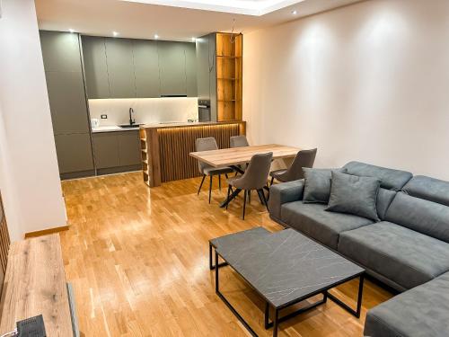 uma sala de estar com um sofá, uma mesa e uma cozinha em Enigma Apartment em Ulcinj