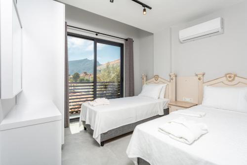 2 camas en una habitación blanca con ventana en Villa Exclusive Paradise 3, en Dalyan