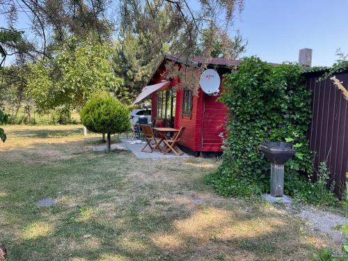 Una cabaña roja con una mesa y un banco en un patio. en Rügen Fewo 181, en Wiek auf Rügen