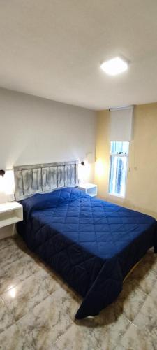 a bedroom with a blue bed in a room at Solaire Apart in Ciudad Lujan de Cuyo