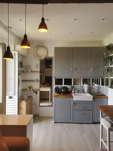 une cuisine avec des placards gris et un comptoir dans l'établissement PETIT PARADIS - St MANDRIER VILLAGE, à Saint-Mandrier-sur-Mer