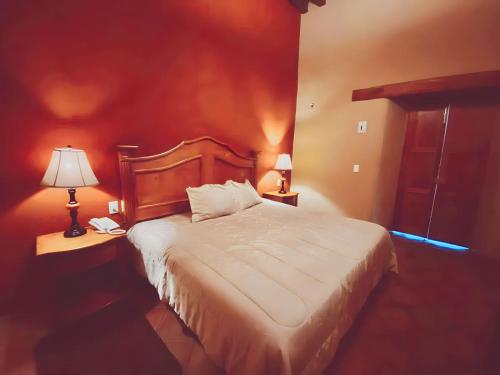 a bedroom with a bed and two lamps on tables at HOTEL PLAZA VASCO in Pátzcuaro