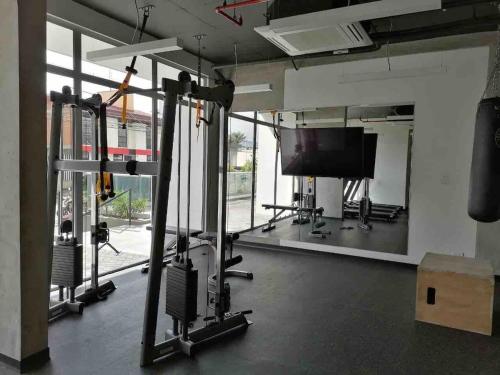 a room with a gym with a tv and weights at Ifreses Apartamento 11 in San José