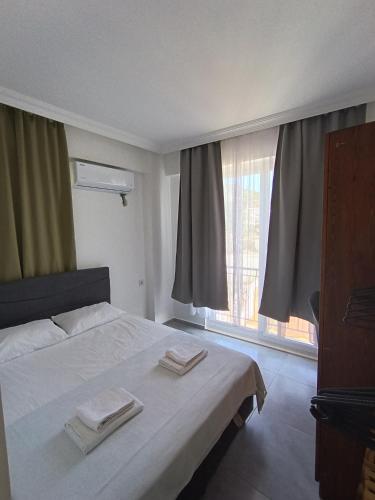 a bedroom with a bed with two towels on it at Ada suit in Kas