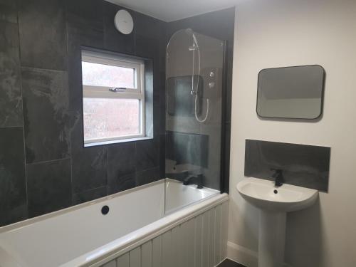 a bathroom with a bath tub and a sink at John Street in Shildon