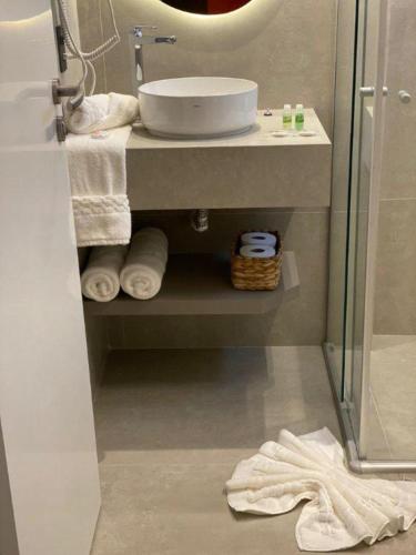 a bathroom with a sink and a mirror and towels at Hotel Porto Real Aparecida in Aparecida