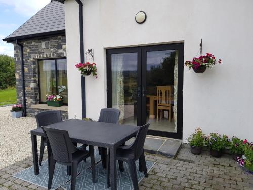 a black table and chairs in front of a house at Atlantic Coast Holiday Home in Mountcharles