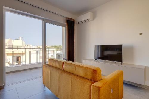 a living room with a couch and a flat screen tv at Valley's Edge Apartments in San Ġwann