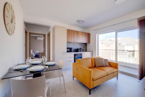 a kitchen and dining room with a table and a chair at Valley's Edge Apartments in San Ġwann