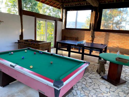 a room with a pool table and two tables at Aconchego no Campo in São Roque
