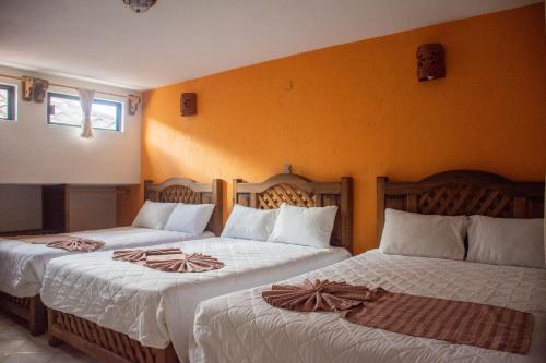 dos camas sentadas una al lado de la otra en una habitación en Hotel Real del Carmen - Ideal para familias y parejas en San Cristóbal de Las Casas