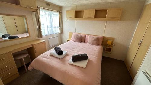 a bedroom with a bed with two towels on it at Holiday Freedom in Clacton-on-Sea