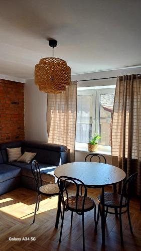 a living room with a table and chairs and a couch at NAD JEZIOREM - Apartamenty in Brenno