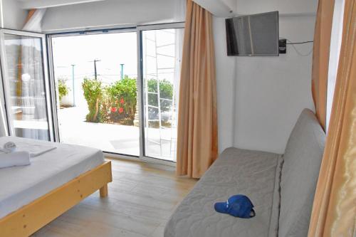 a bedroom with a bed and a sliding glass door at Euripidean View, Apartments in Salamina
