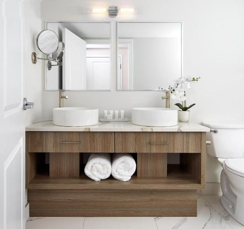 a bathroom with two sinks and a mirror at The Glenerin Inn in Mississauga