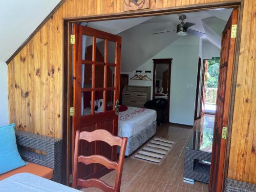 a bedroom with a bed and a door leading into a room at Chloe's Cottage Self-Catering in La Digue