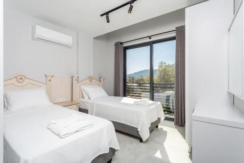 two beds in a room with a large window at Villa Exclusive Paradise 2 in Dalyan