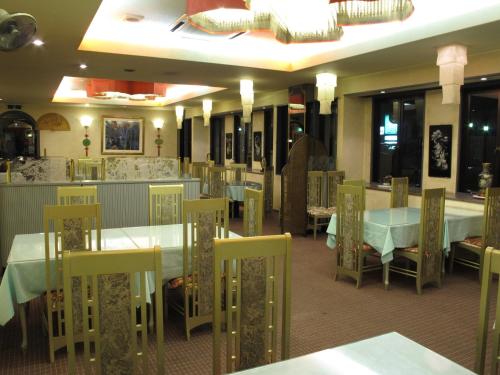 uma sala de jantar com mesas brancas e cadeiras amarelas em Business hotel Green Plaza - Vacation STAY 43971v em Chikuma