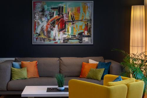 a living room with a couch with colorful pillows at Apartment Sladic in Sisak