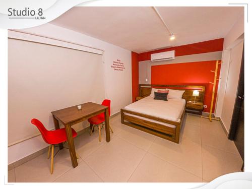 a small bedroom with a bed and a table and chairs at Studio8 Lujan Apartament 1 in San José