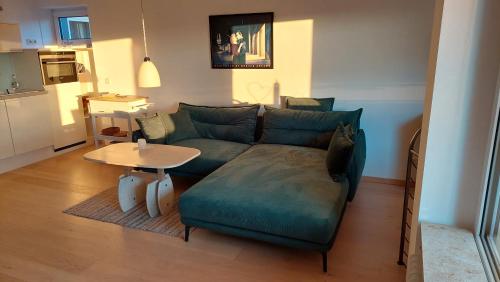a living room with a green couch and a table at Ferienwohnung sunset Weissenstadt in Weißenstadt