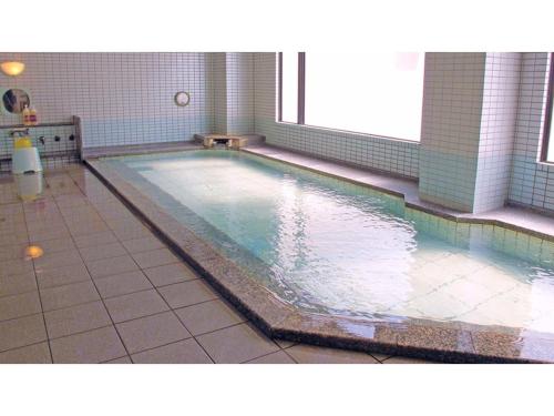 Business hotel Green Plaza - Vacation STAY 43933v في Chikuma: مسبح في حمام ارضيه بلاط