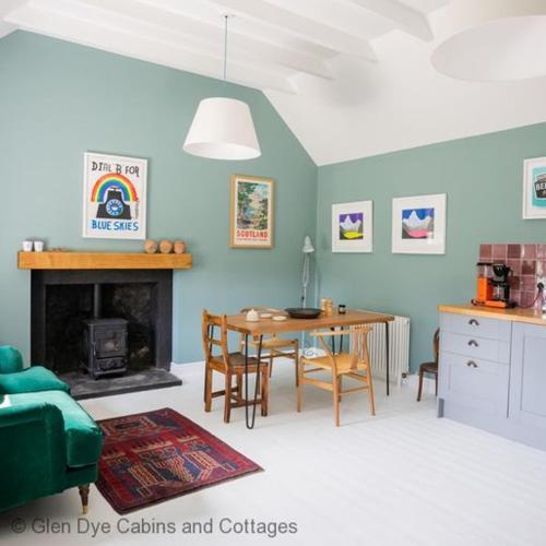 a living room with a table and a green couch at The Bothy in Banchory