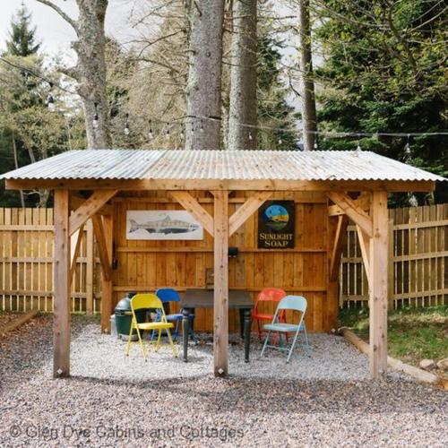 a wooden gazebo with chairs and a table at The Bothy in Banchory