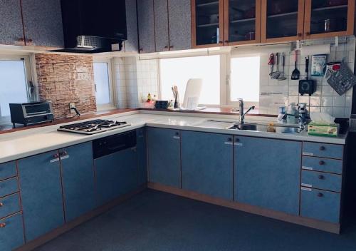 a kitchen with blue cabinets and a sink at Kamome Building 3F - Vacation STAY 54301v in Otaru