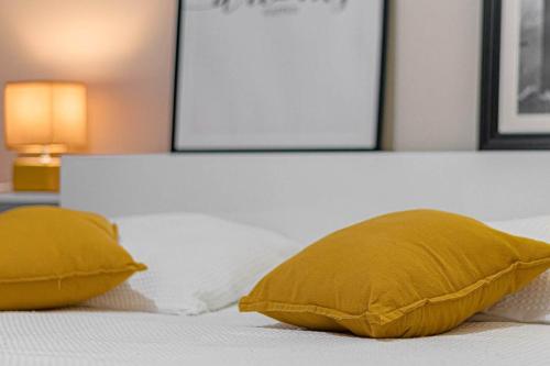 - un lit avec 2 oreillers jaunes dans l'établissement Les 70's Dutreix, à Limoges
